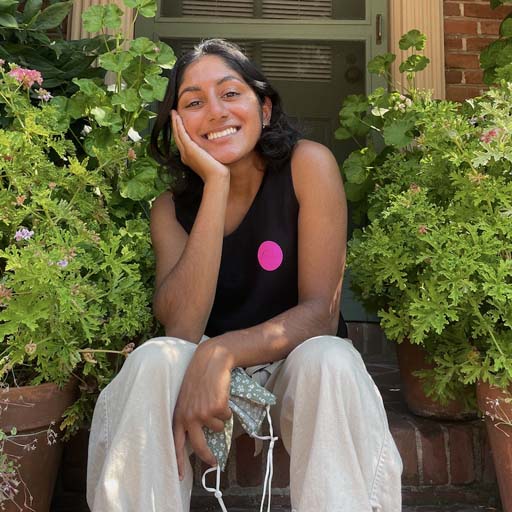 Maya smiling surrounded by plants